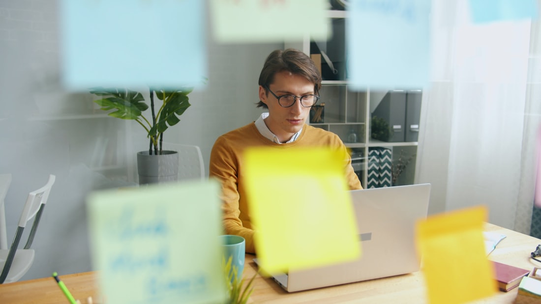 A designer working through screen ideas at a laptop.
