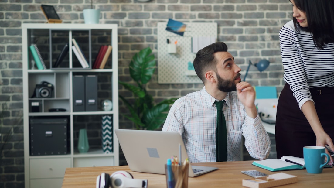 Two colleagues working through an issue at a shared desk.